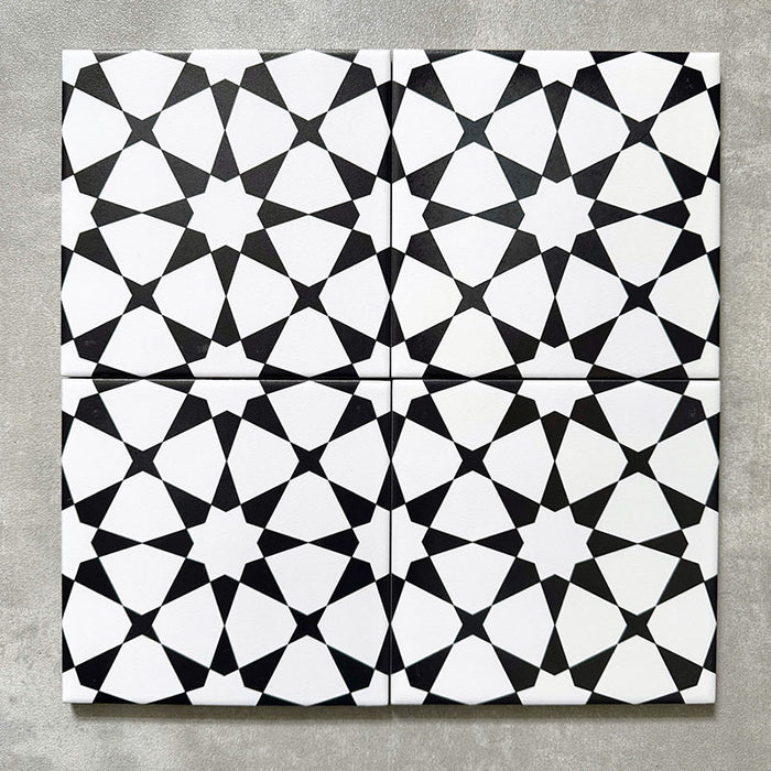 Agadir MINI Schwarz & Weiß Fliesen im marokkanischen Stil im Format 15 × 15 cm aus Feinsteinzeug, als Vierer-Anordnung dargestellt, um das sich wiederholende geometrische Sternmuster in Schwarz und Weiß auf neutralem Hintergrund zu zeigen.