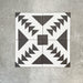 Almeira Azteca Feinsteinzeug-Bodenfliesen im marokkanischen Stil, dargestellt in einer Vierer-Anordnung, die das markante geometrische Muster in Schwarz und Weiß mit gestuften Dreiecken und zentralen Details zeigt, Format 20 × 20 cm.