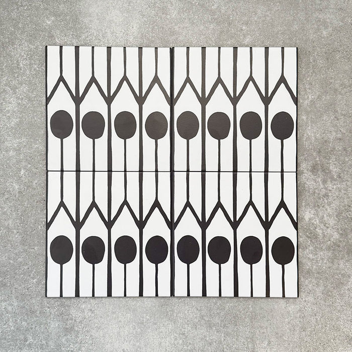 Vier Almeira Felis Feinsteinzeugfliesen im marokkanischen Stil für Wand und Boden, gemeinsam präsentiert in einem markanten geometrischen Punkt- und Linienmuster in Schwarz und Weiß, Format 20 × 20 cm.