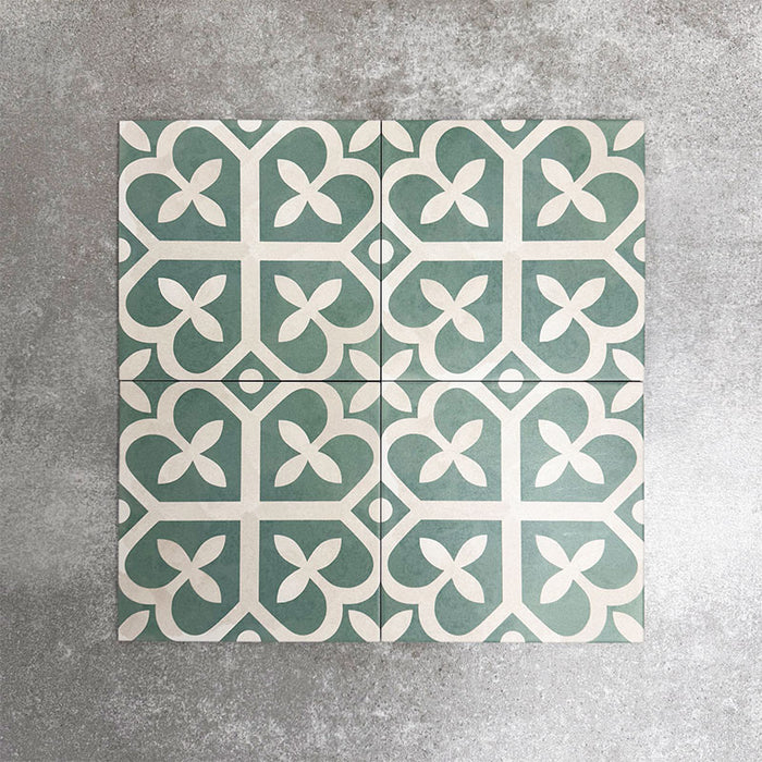 Vier Kuba Ivy Grün Feinsteinzeugfliesen im viktorianisch-marokkanischen Stil im Format 20 × 20 cm, gemeinsam angeordnet, um das sich wiederholende geometrische Muster in Grün und Weiß zu zeigen.