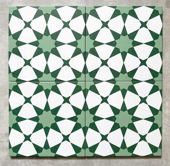 Agadir Grün Fliesen im marokkanischen Stil im Format 20 × 20 cm aus Feinsteinzeug, als Vierer-Anordnung dargestellt, um das sich wiederholende geometrische Sternmuster in Grün und Weiß auf neutralem Hintergrund zu zeigen.