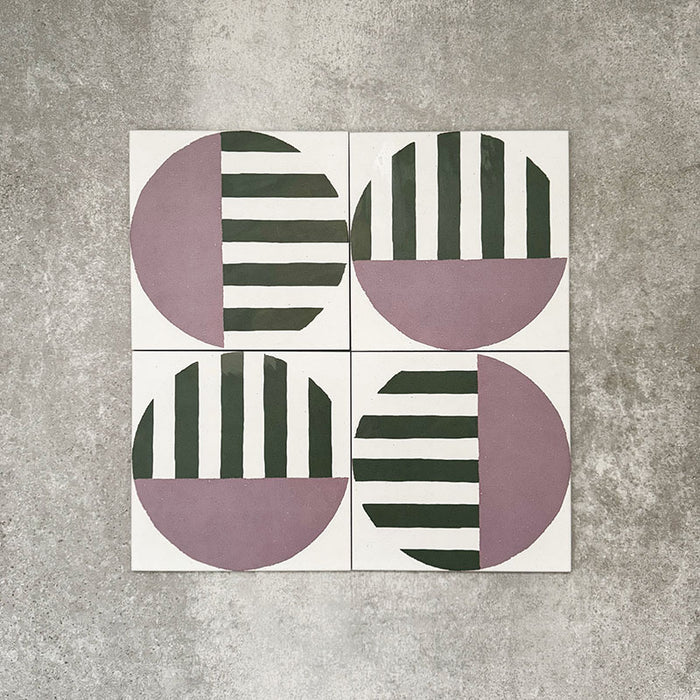 Abstrakter Serit Musterfliese im Format 20 × 20 cm, in einem wiederholten Raster verlegt, um das ausdrucksstarke geometrische Design zu zeigen. Sanft rosafarbene Halbkreise werden mit tiefgrünen horizontalen Streifen auf klarem weißem Hintergrund kombiniert und ergeben ein verspieltes, zugleich zeitgemäßes Muster – ideal für Akzentwände, Bodenflächen oder ausdrucksstarke Küchenrückwände.
