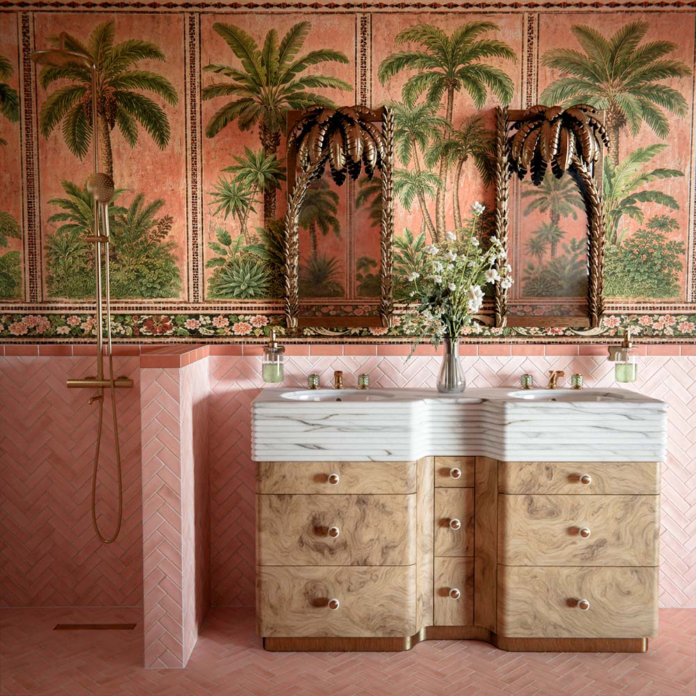 Badezimmer mit Atlas Pink Moroccan Mini Brick Matt Wandfliesen im Format 5 × 15 cm im Fischgrätmuster, kombiniert mit tropischer Palmentapete, geschnitzten Holzspiegeln und Waschbecken in Marmoroptik für ein luxuriöses, eklektisches Interior.