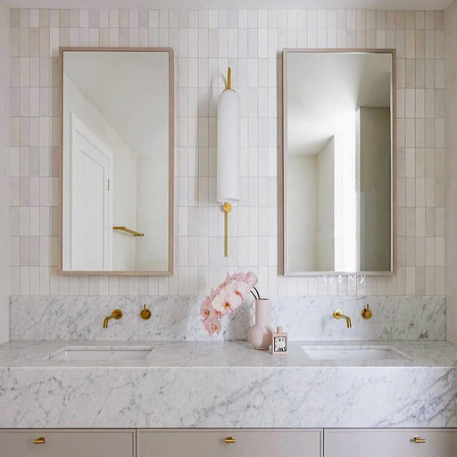 Badezimmer mit Atlas White Mini Brick Gloss glänzenden Wandfliesen im Format 5 × 15 cm, kombiniert mit Marmoroberflächen, Armaturen in Messingoptik und sanften neutralen Farbtönen für ein elegantes, modernes Badezimmerdesign.