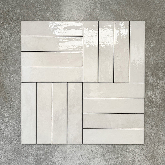 Nomadin Brick Weiß Wandfliesen im Format 6 × 24,6 cm, im Flechtmuster verlegt, um den sanften Weißton, die glänzende Oberfläche und die feine Oberflächenvariation zu betonen.