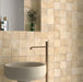Badezimmerwand mit Zellige Sandbeige Matt Quadrat Keramikfliesen im marokkanischen Stil im Format 10 × 10 cm, in sanften Beige- und Sandtönen. Im klassischen Raster rund um ein freistehendes Waschbecken mit Messingarmatur verlegt, sorgen feine Farbnuancen und leicht unregelmäßige Kanten für ein authentisches, handgefertigtes Zellige-Effekt-Finish.