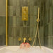 Badezimmer mit Zellige Malachitgrün Matt Keramik-Riemchenfliesen im marokkanischen Stil im Format 6,5 × 20 cm, rund um Badewanne und Dusche an den Wänden verlegt. In Kombination mit gebürsteten Messingarmaturen, einem Waschtisch aus Holz und einem Steinwaschbecken entsteht ein warmes, spa-ähnliches Ambiente.