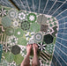 Badezimmer mit Fayrouz Verde Hexagon Patchwork Feinsteinzeugfliesen im marokkanischen Stil im Hexagonformat 18,7 × 21,6 cm. Die Kombination aus filigranen geometrischen und sternförmigen Mustern in abgestuften Grün-, Salbei- und Anthrazittönen wird mit tiefblauen glasierten Wandfliesen, Armaturen in gebürsteter Messingoptik und einer geschwungenen Walk-in-Dusche ergänzt und schafft ein ausdrucksstarkes, charaktervolles Gesamtbild.