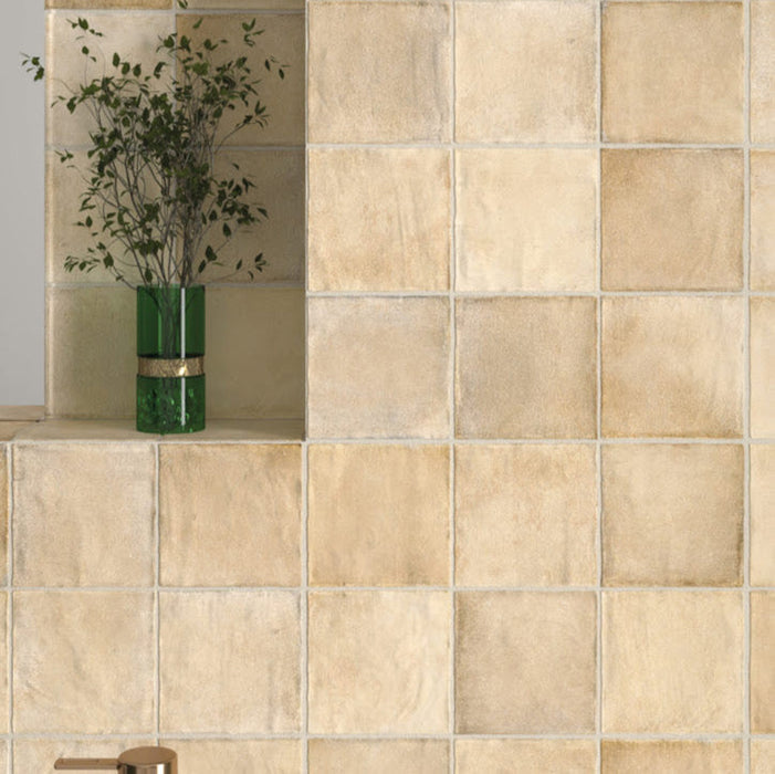 Badezimmerwand mit Zellige Sandbeige Matt Quadrat Keramikfliesen im marokkanischen Stil im Format 10 × 10 cm, in weichen Beige- und Sandtönen. Im klassischen Raster rund um ein freistehendes Waschbecken mit Messingarmatur verlegt, erzeugen subtile Farbunterschiede und leicht unregelmäßige Kanten ein authentisches Zellige-Finish in handgefertigter Anmutung.