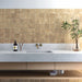 Badezimmer-Spritzschutz mit Zellige Sandbeige Matt Quadrat Keramik-Wandfliesen im marokkanischen Stil im Format 10 × 10 cm, in warmen Beigetönen. Sauber im Raster oberhalb eines Waschtischs in Betonoptik mit wandmontierten Messingarmaturen verlegt, sorgen feine Farbvariationen und sanft unregelmäßige Kanten für eine authentische Zellige-Optik.