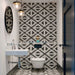 Almeira Azteca Feinsteinzeug-Bodenfliesen im marokkanischen Stil in einem modernen Badezimmer, mit einem markanten geometrischen Dreiecksmuster in Schwarz und Weiß, kombiniert mit weißen Metro-Wandfliesen, Format 20 × 20 cm.