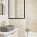 Badezimmer mit Zellige Beige quadratischen Fliesen im marokkanischen Stil in sanften, neutralen Tönen, kombiniert mit Armaturen in Messing und einem Waschbecken aus Stein.