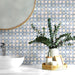 Badezimmerwand mit Berber Mequinez Blau Feinsteinzeugfliesen im marokkanischen Stil im Format 15 × 15 cm. Das geometrische Muster in Blau und Creme wird mit einem Aufsatzwaschbecken und Grünpflanzen kombiniert und sorgt für eine frische, wohnliche Atmosphäre.