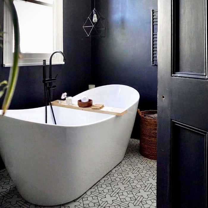 Badezimmer mit Almeira Palast Feinsteinzeugfliesen im marokkanischen Stil als Bodenbelag im Format 20 × 20 cm, mit einem eleganten geometrischen Linienmuster in Schwarz. Kombiniert mit einer freistehenden Badewanne und dunkel gestrichenen Wänden für eine ausdrucksstarke, stilvolle Atmosphäre.