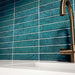 Küchenrückwand mit Bora Bora Brick Amun Blue Wandfliesen im Format 6,5 × 32,8 cm, die die satten blau schimmernden Flux-Glasureffekte zur Geltung bringen. Kombiniert mit einer weißen Arbeitsplatte, einem integrierten Spülbecken und einer Armatur in gebürsteter Messingoptik entsteht ein eleganter und zeitgemäßer Look.