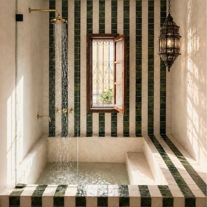Badezimmer im marokkanischen Stil mit Bora Bora Quadrat Weißer Sand Wandfliesen im Format 10 × 10 cm, kombiniert mit dunkelgrünen quadratischen Fliesen in einem Streifendesign rund um eine eingelassene Badewanne und den Duschbereich.