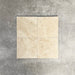 Vier Fayrouz Cappuccino 15,2 × 15,2 cm Naturmarmorfliesen mit getrommelter Oberfläche nebeneinander angeordnet, die sanften Cremetöne, feine Maserung und natürliche Variation vor einem neutralen, strukturierten Hintergrund zeigen.
