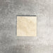 Einzelne Fayrouz Cappuccino 15,2 × 15,2 cm Naturmarmorfliese mit getrommelter Oberfläche in sanften Cremetönen mit feiner natürlicher Maserung, präsentiert vor einem neutralen, strukturierten Hintergrund in einer klaren Produktszene.