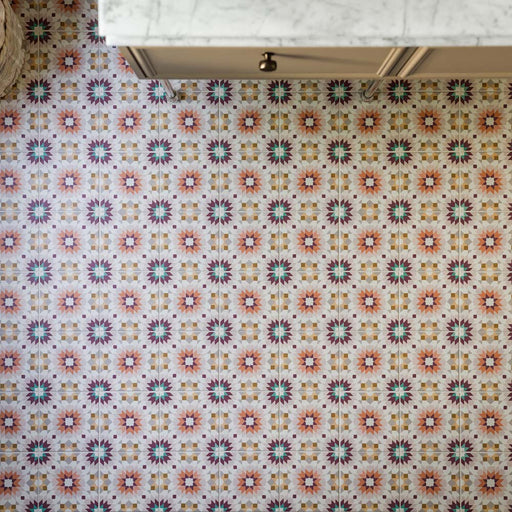 Boden mit Kuba Manzanillo Musterfliesen im Format 20 × 20 cm im marokkanischen Stil, mit einem detailreichen geometrischen Design in Rosa, Grün, Burgunderrot und warmen neutralen Tönen, das unter klassischen Schränken einen farbenfrohen Blickfang schafft.