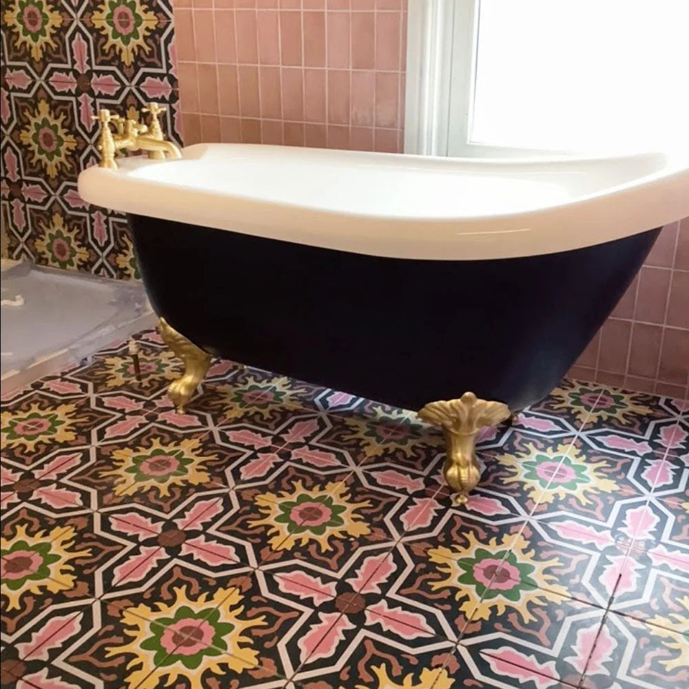 Badezimmerboden mit Kuba Havana Feinsteinzeugfliesen im marokkanischen Stil im Format 20 × 20 cm, in satten, mehrfarbigen Tönen verlegt. Kombiniert mit einer freistehenden Badewanne und Armaturen in Messingoptik entsteht ein ausdrucksstarkes, charaktervolles und dekoratives Bad.
