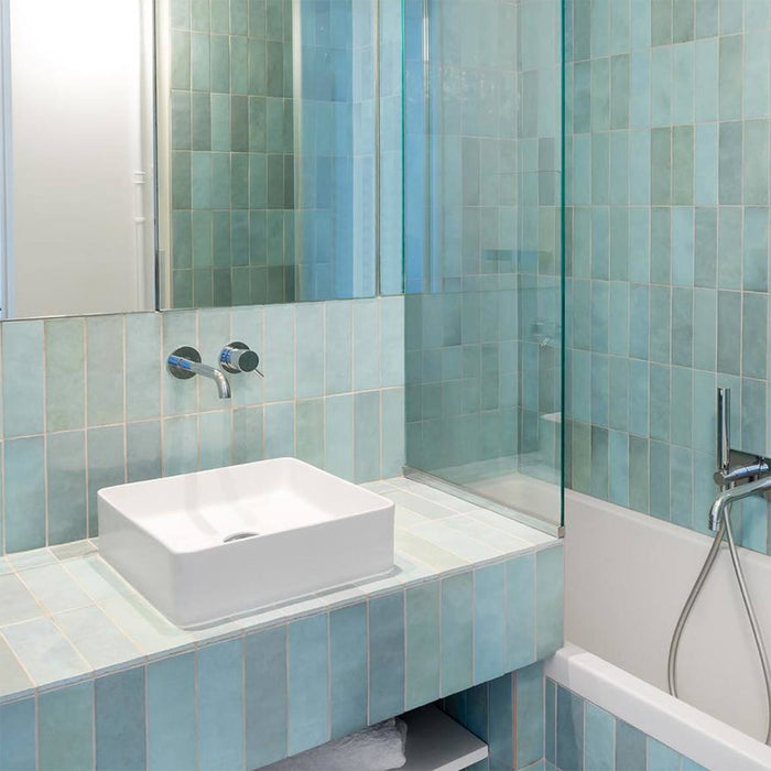 Badezimmer mit Zellige Aquablau Ziegel Wandfliesen im marokkanischen Stil im Format 6,5 × 20 cm, vertikal rund um Waschbecken und Badewanne verlegt. Die zarten Blau-Grün-Töne schaffen eine frische, beruhigende Atmosphäre mit dezenter handgefertigter Variation.