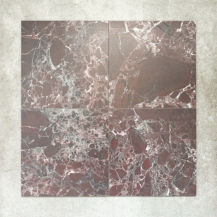 Close-up of Divine Levant Rouge matt marble-effect tile in a 30cm x 30cm format, featuring deep burgundy and rich red tones with intricate white and grey marble-inspired veining. The bold natural stone effect and dramatic colour variation create a luxurious statement finish, ideal for chequerboard floor designs, feature areas and characterful interior spaces.