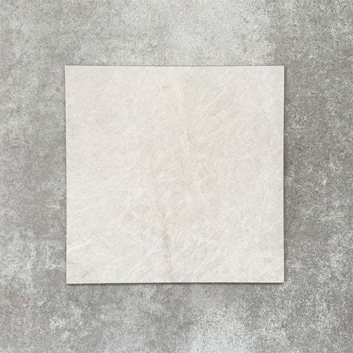 Close-up of Divine Taj Mahal matt marble-effect tile in a 30cm x 30cm format, featuring soft ivory and warm cream tones with subtle natural stone-inspired movement. The understated marble effect creates a timeless and elegant finish, making it ideal for chequerboard floor designs, bathrooms, hallways and sophisticated interior spaces.