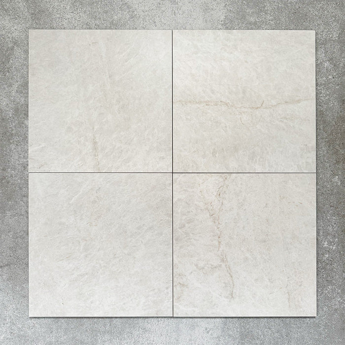 Close-up of Divine Taj Mahal matt marble-effect tile in a 30cm x 30cm format, featuring soft ivory and warm cream tones with subtle natural stone-inspired movement. The understated marble effect creates a timeless and elegant finish, making it ideal for chequerboard floor designs, bathrooms, hallways and sophisticated interior spaces.