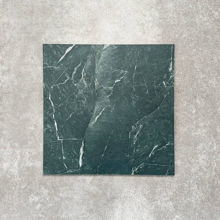 Close-up of Divine Verde Green matt marble-effect tile in a 30cm x 30cm format, featuring rich green tones with elegant white veining and natural marble-inspired movement. The bold stone effect creates a luxurious, timeless finish, making it ideal for statement chequerboard floors, feature areas and sophisticated interior schemes.