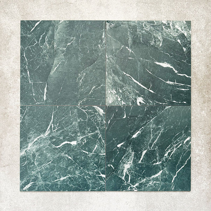 Close-up of Divine Verde Green matt marble-effect tile in a 30cm x 30cm format, featuring rich green tones with elegant white veining and natural marble-inspired movement. The bold stone effect creates a luxurious, timeless finish, making it ideal for statement chequerboard floors, feature areas and sophisticated interior schemes.