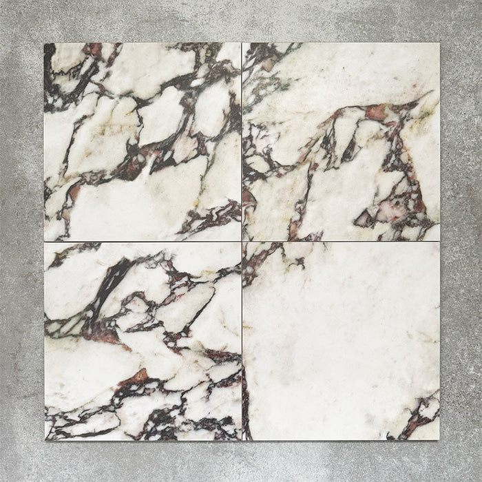 Close-up of Divine Viola matt marble-effect tile in a 30cm x 30cm format, featuring a crisp white background with dramatic burgundy, plum and charcoal veining. Inspired by luxurious natural marble, the striking contrast and rich colour variation make it ideal for statement chequerboard floors, feature areas and elegant interior schemes.