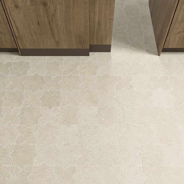 Nahaufnahme der Dohar Sands Star & Cross Wand- und Bodenfliesen mit dekorativem geometrischem Muster in warmen, von Sand inspirierten Farbtönen. Kombiniert mit Küchenfronten aus Naturholz entsteht ein stilvolles und modernes Bodendesign mit zeitloser Ausstrahlung.