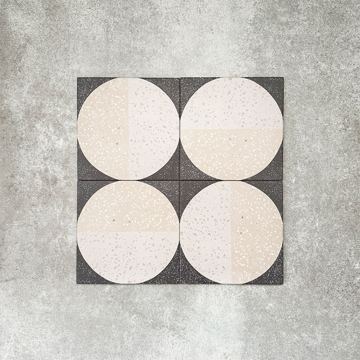 Nahaufnahme der Eclipse Lunar Dekorfliesen im Terrazzo-Look im Format 20 × 20 cm in sanften Creme- und Anthrazittönen, mit geometrischen Kreisdesigns und gesprenkelten Details.