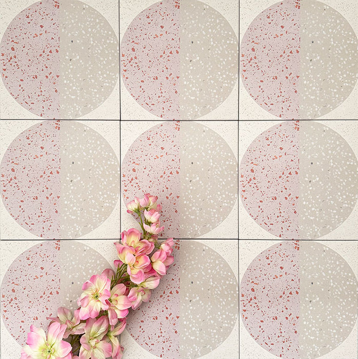 Nahaufnahme der Eclipse Rosa Dekorfliesen im Terrazzo-Look im Format 20 × 20 cm in sanften Blush- und Cremetönen, mit geometrischen Kreisdesigns und gesprenkelten Details, kombiniert mit rosa floralen Akzenten.