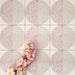 Nahaufnahme der Eclipse Rosa Dekorfliesen im Terrazzo-Look im Format 20 × 20 cm in sanften Blush- und Cremetönen, mit geometrischen Kreisdesigns und gesprenkelten Details, kombiniert mit rosa floralen Akzenten.