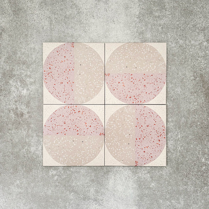 Nahaufnahme der Eclipse Rosa Dekorfliesen im Terrazzo-Look im Format 20 × 20 cm in sanften Blush- und Cremetönen, mit geometrischen Kreisdesigns und gesprenkelten Details, kombiniert mit rosa floralen Akzenten.