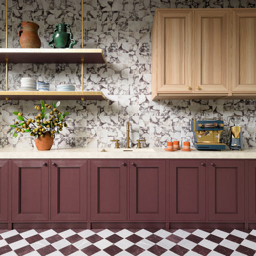 Kitchen featuring Fayrouz Viola Honed Finish natural marble 15.2cm x 15.2cm wall tiles as a splashback, paired with burgundy cabinetry, a matching chequerboard marble floor, oak cupboards and brushed brass fittings.