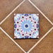 Produktabbildung der Fez Fiera Mini Feinsteinzeugfliese im Format 15 × 15 cm im Moroccan Style mit filigranem geometrischem Muster in sanften Blau-, Rosa-, Burgunder- und Grautönen, die das dekorative Design in Encaustic-Optik zeigt, inspiriert von traditionellen marokkanischen Zementfliesen.
