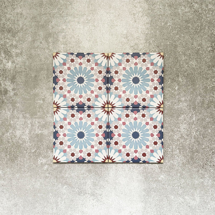 Vier Fez Mini Messe Fliesen im Format 15 × 15 cm im marokkanischen Stil, zusammen angeordnet und mit einem detailreichen geometrischen Muster in sanften Blau-, Rosa-, Burgunder- und Cremetönen auf einem strukturierten neutralen Hintergrund.