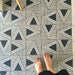 Bodenfläche mit Almeira Giza Feinsteinzeugfliesen im marokkanischen Stil in einem kräftigen geometrischen Dreiecksmuster in Schwarz und Weiß, Format 20 × 20 cm, für eine moderne und ausdrucksstarke Optik.