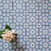 Fez Mini Artisan 15x15cm Moroccan-style porcelain wall tiles arranged in a repeating geometric pattern, featuring soft blue, blush pink, green and terracotta star motifs, styled with pale floral accents for a decorative, characterful finish.