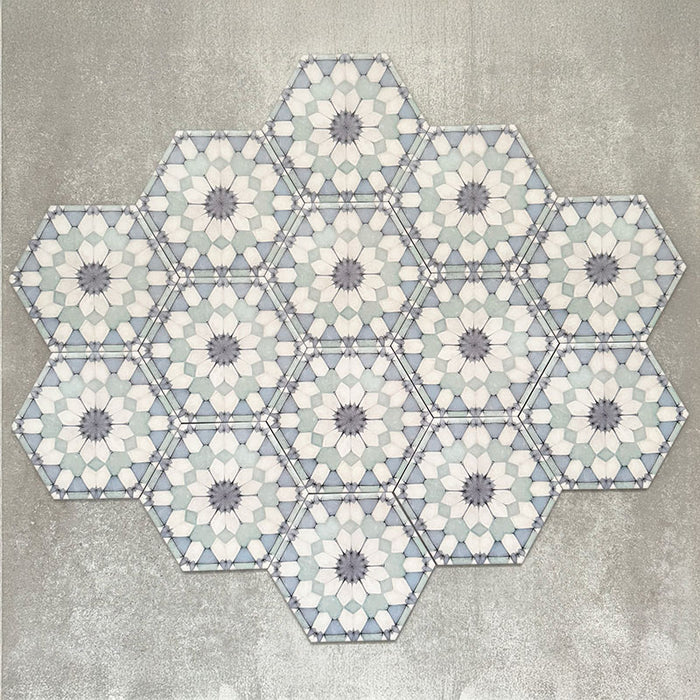 Gruppierte Anordnung von Medina Frostblau Feinsteinzeug-Hexagonfliesen im marokkanischen Stil im Format 18,7 × 21,6 cm, die das vollständig wiederholte geometrische Muster in sanften Blau- und Weißtönen auf neutralem Hintergrund zeigt.
