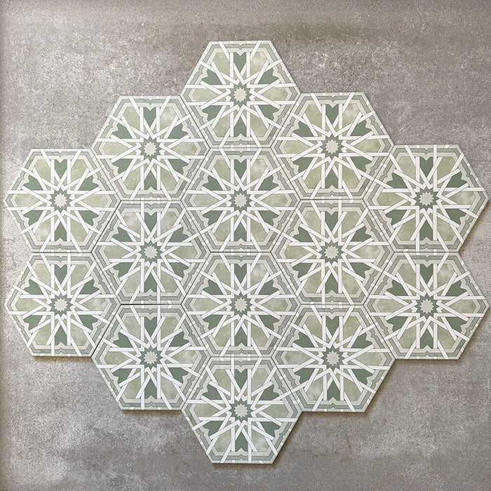 Gruppierte Anordnung von Medina Hormuz Grün Feinsteinzeug-Hexagonfliesen im marokkanischen Stil im Format 18,7 × 21,6 cm, die das vollständig wiederholte geometrische Muster in sanften Blau- und Weißtönen auf neutralem Hintergrund zeigt.