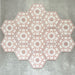 Gruppierte Anordnung von Medina Rosa Feinsteinzeug-Hexagonfliesen im marokkanischen Stil im Format 18,7 × 21,6 cm, die das vollständige, sich wiederholende geometrische Muster in zarten Altrosa- und Weißtönen auf neutralem Hintergrund zeigt.
