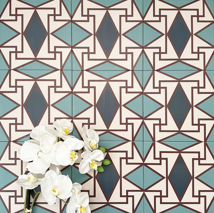 Abstrakter Iris Musterfliese im Format 20 × 20 cm, in einem wiederholten Raster verlegt, um das detailreiche geometrische Design zu zeigen. Sanfte Petrol- und Cremetöne stehen im Kontrast zu tiefblauen Rautenmotiven und feinen roten Details und ergeben ein ausdrucksstarkes, dekoratives Muster – ideal für Akzentwände, Bodenflächen oder ausdrucksstarke Küchenrückwände.
