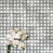 Berber Mequinez Grün Feinsteinzeugfliesen im marokkanischen Stil im Format 15 × 15 cm, verlegt im Raster, um das weiche geometrische Design in Grün und Creme zu zeigen. Mit floraler Dekoration in Szene gesetzt für eine wohnliche, dekorative Wirkung.