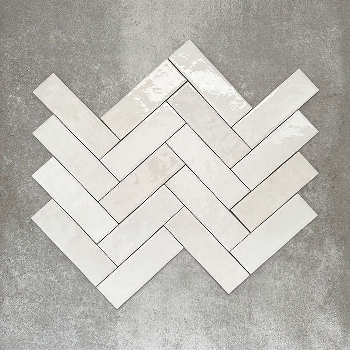 Zellige Weiß Ziegel Fliesen im Fischgrätmuster verlegt, mit glänzend weißem Finish und natürlicher tonaler Variation.