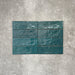 Flatlay von Zellige Pfauengrün Keramik-Ziegelfliesen im marokkanischen Stil im Format 6,5 × 20 cm, mit satten Blau-Grün-Tönen, glänzender Glasur und natürlicher Farbvariation auf neutralem Hintergrund.