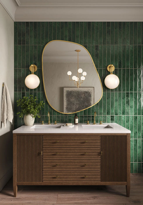 Waschplatz im Badezimmer mit Malediven Grün Wandfliesen im Format 5 × 40 cm aus glänzender Keramik, vertikal verlegt mit intensiver grüner Tonvariation. Kombiniert mit einem Waschtischunterschrank aus Holz, Messingarmaturen, zwei Waschbecken und einem markanten Spiegel für eine hochwertige, stilvolle Gesamtwirkung.