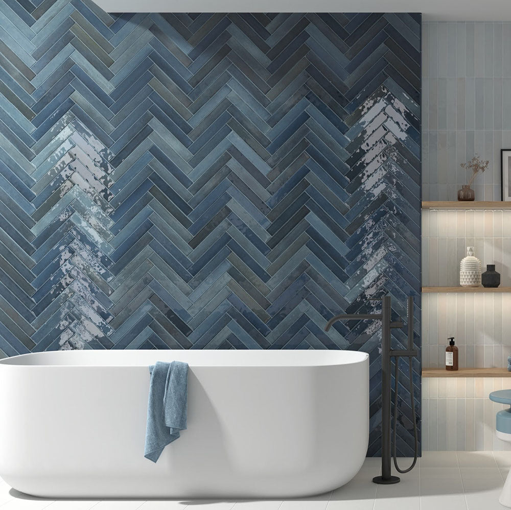 Modernes Badezimmer mit Lisbon Blue Green Wandfliesen aus Feinsteinzeug im handwerklichen Stil im Format 5 × 30 cm, im Fischgrätmuster verlegt, um eine ausdrucksstarke Akzentwand zu schaffen. Kombiniert mit einer freistehenden Badewanne, schwarzen Armaturen und sanften blauen Akzenten entsteht ein luxuriöses, spa-inspiriertes Interior.